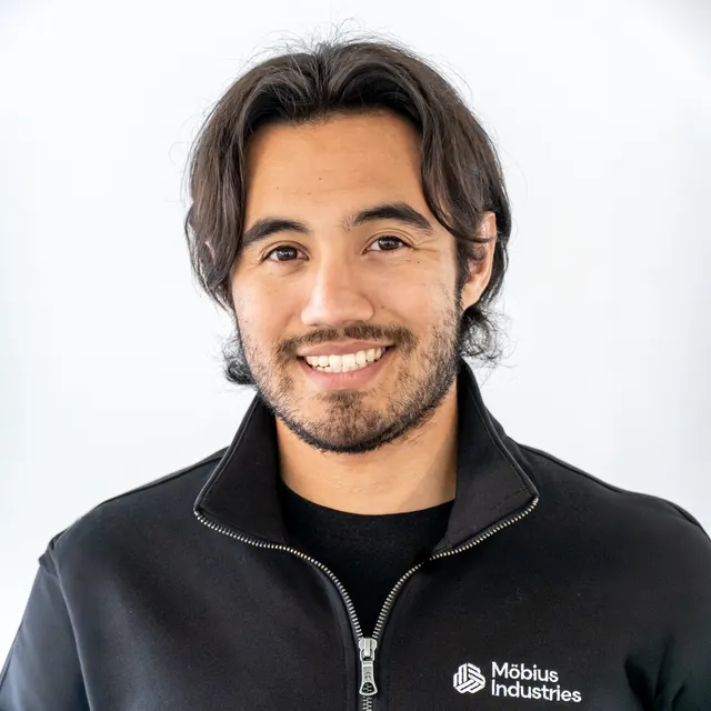 Karl Velazquez, studio headshot in a Möbius Industries jacket