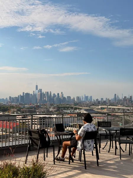 Karl practicing DJing solo on a rooftop with the Manhattan skyline behind him